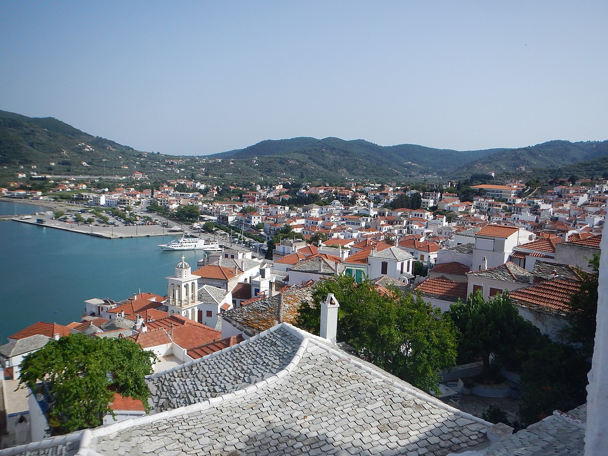 media/plg_solidres_experience/images/9908279ebbf1f9b250ba689db6a0222b/Skopelos/1200px-Panoramic_view_of_Skopelos_city.jpg